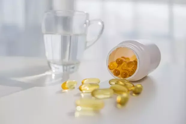 ขวดวิตามินวางอยู่ข้างแก้วน้ำ ขวดวิตามินวางอยู่ข้างแก้วน้ำ