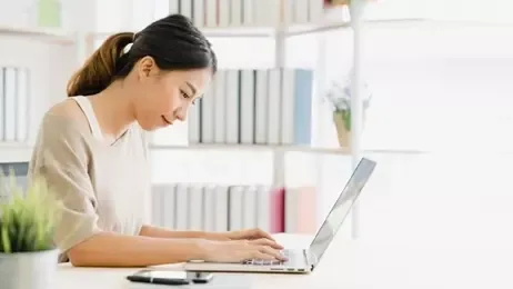 ผู้หญิงกำลังเช็คสิทธิประกันสังคมด้วยโน๊ตบุ๊ค