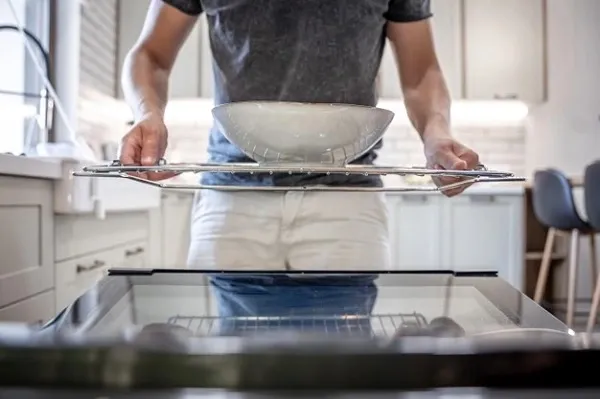 ผู้ชายเอาจานใส่เครื่องล้างจาน