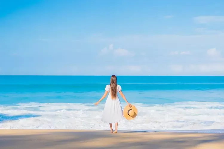 ผู้หญิงกำลังยืนเล่นอยู่ที่ชายหาด